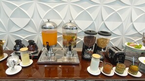 Un espace dédié au café, équipé de divers appareils et récipients pour la préparation, notamment une cafetière à piston, un mousseur à lait et plusieurs distributeurs pour le café et le lait.