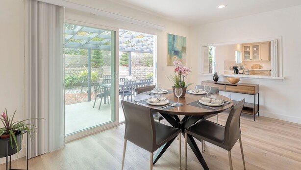 A modern dining area with a glass door leading to an outdoor patio, a kitchen with a view, and a dining table set for six. - 3896 Gather and Rest - Mountain Views, Large Patio (Del Rey Oaks)