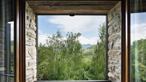 A view through a window with stone walls, featuring a lush green landscape with trees and hills in the distance. - Villa Torre delle Rose by Geco Vacation Rentals (Visignano)