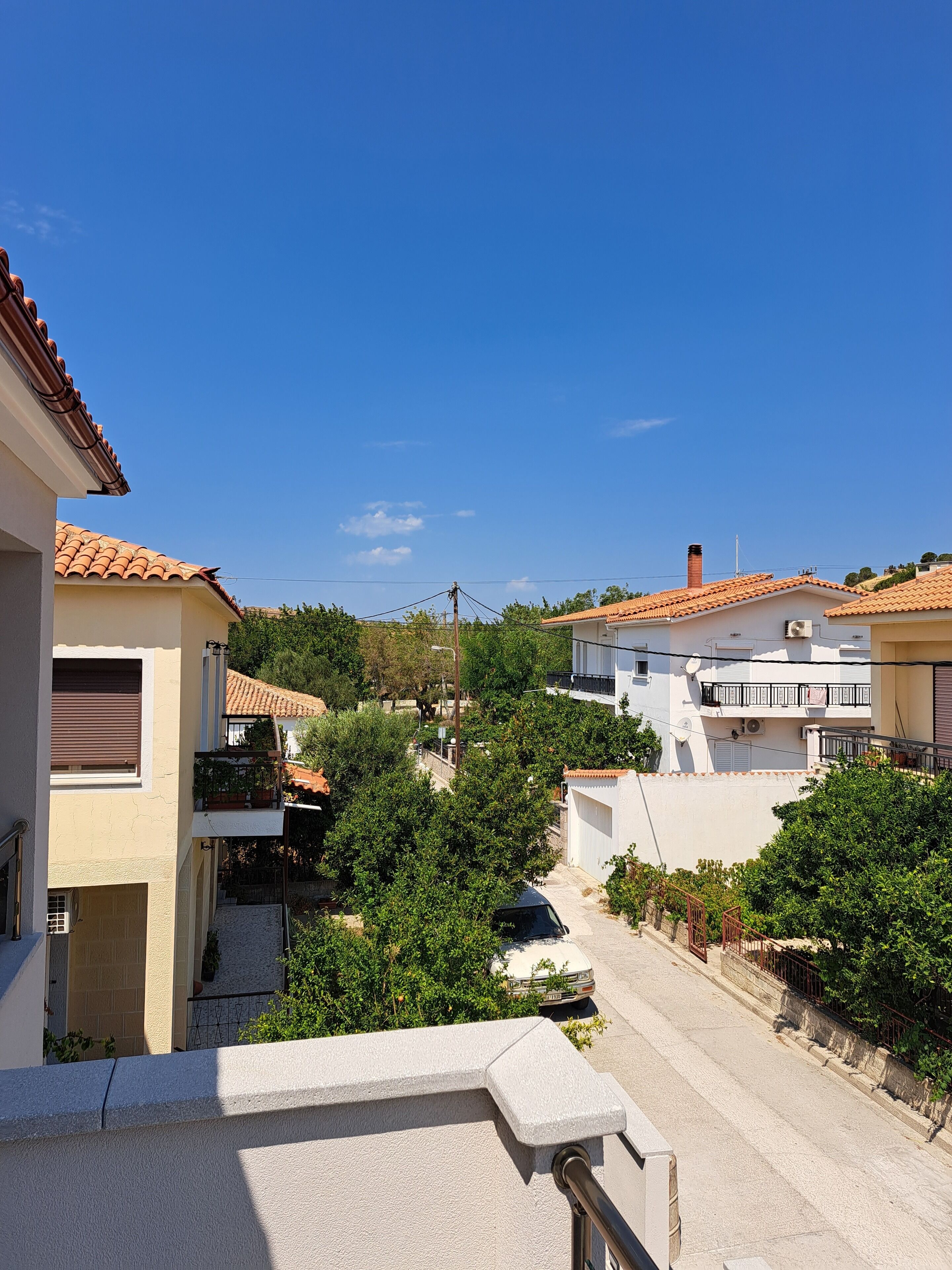 A residential area with terracotta-tiled roofs, white walls, and balconies.