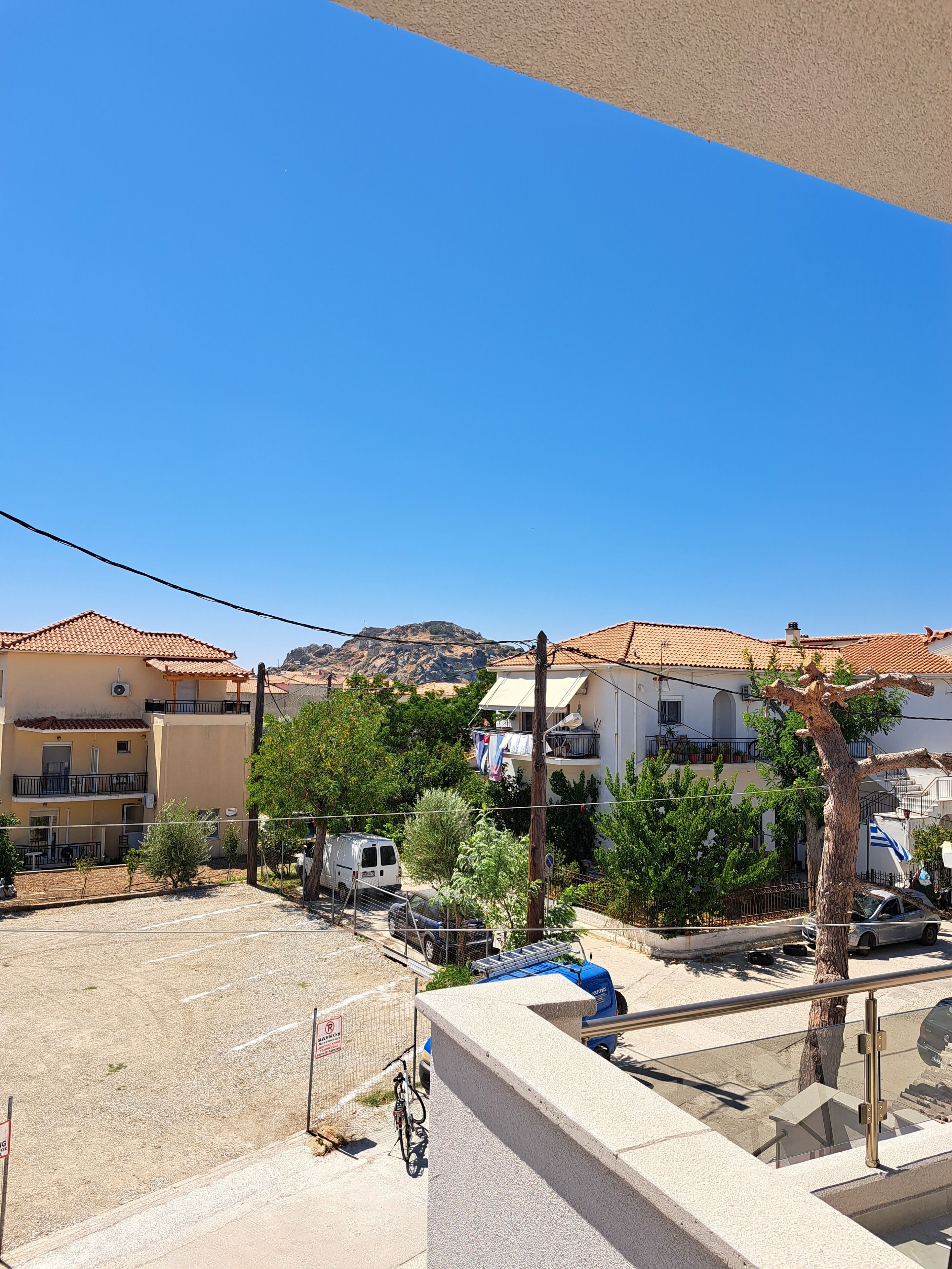 Zona residencial con edificios, una furgoneta estacionada y una bicicleta.