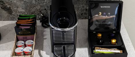 A coffee machine, a box of coffee pods, and a display of coffee capsules.