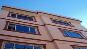 A multi-story building with a symmetrical facade, featuring evenly spaced windows and a central entrance. - MeroStay 251 Hotel Air (Kathmandu)