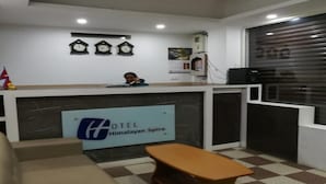 A hotel reception area with a reception desk, a clock, and a small seating area. - MeroStay 251 Hotel Air (Kathmandu)