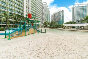 On the beach, white sand, sun loungers, beach towels - O&O Group- 1BR Azure Resort Pool Beach Netflix (Parañaque)