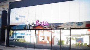 The exterior of the Ipe Rosa Hotel with a large glass facade and a prominent sign. - Ipê Rosa Hotel (Bauru)