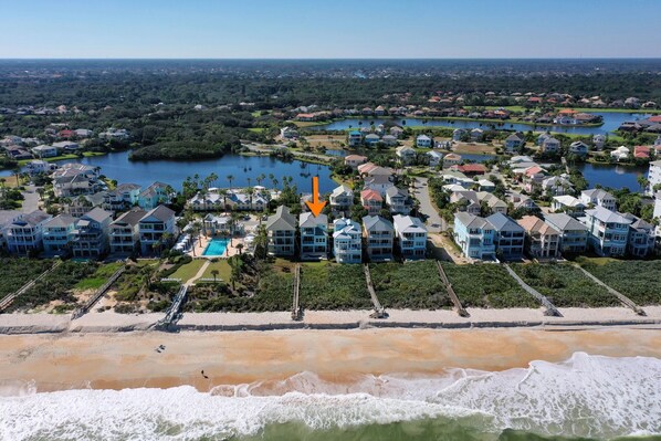 Una zona residencial costera con propiedades frente a la playa, un puerto deportivo y una extensa masa de agua.