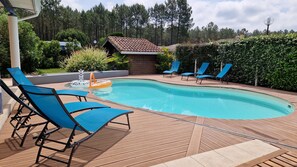 A swimming pool with blue lounge chairs and a small inflatable float. - La Villa du Marensin (Lit-et-Mixe)