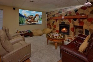 Een woonkamer met een open haard, een bank, een salontafel en een televisie.