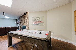 Ein Zimmer mit Billardtisch, einer Tafel mit Notizen und einer Steinwand.