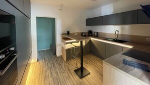 A modern kitchen with a built-in oven, a coffee maker, and a sink. - Modern vacation apartment "Stilapartment Oasis 1" close to the center (Wernigerode)