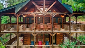 Une cabane en bois dotée d’un balcon et de nombreuses fenêtres.