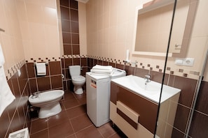 A bathroom with a toilet, bidet, and washing machine. - Aparthotel Punct pe i (Sighetu Marmatiei)