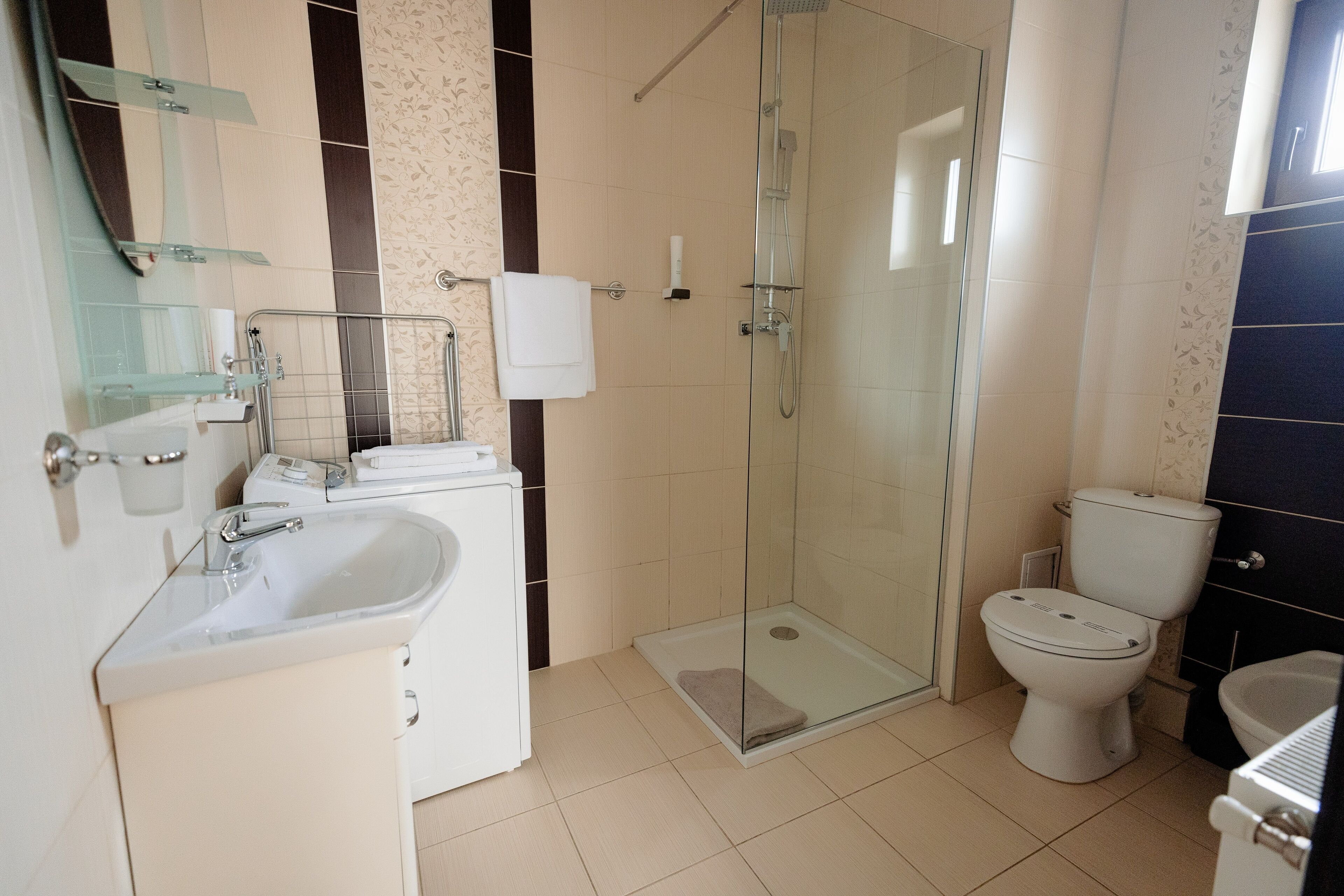 A modern bathroom with a glass-enclosed shower, a white sink, and a toilet.
