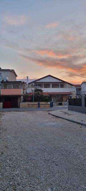 A residential area with houses, a gravel driveway, and a clear sky.