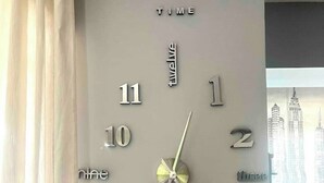 Et vægur med minimalistisk design, store tal og en central time- og minutviser.
