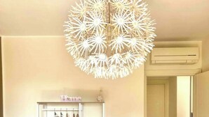 Et soveværelse med seng, garderobeskab, cirkulær loftlampe og en gang.