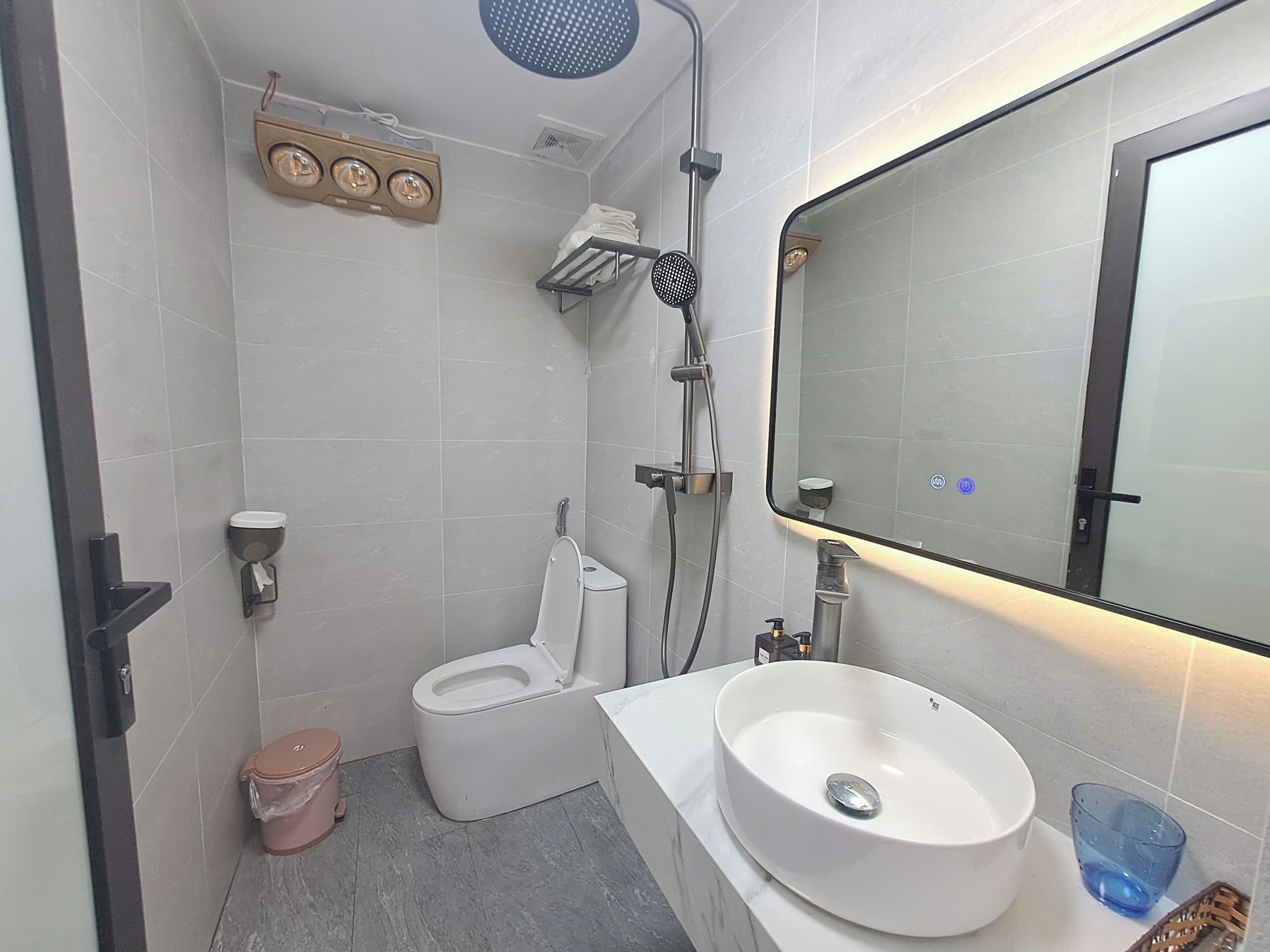 A modern bathroom with a toilet, sink, and shower.