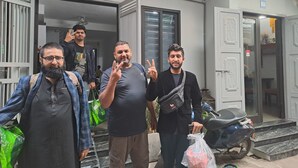 A group of people standing outside a building with a sign indicating 'Blue Home Homestay' and a contact number. - Blue Homestay Cau Giay (Hanoi)