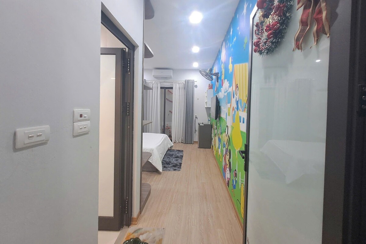 A hallway with a bed, a fan, and a wall with a mural.