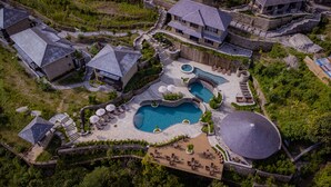 Oversigtsbillede af et resort med flere swimmingpools, et stort overdækket område og stendækkede stier.
