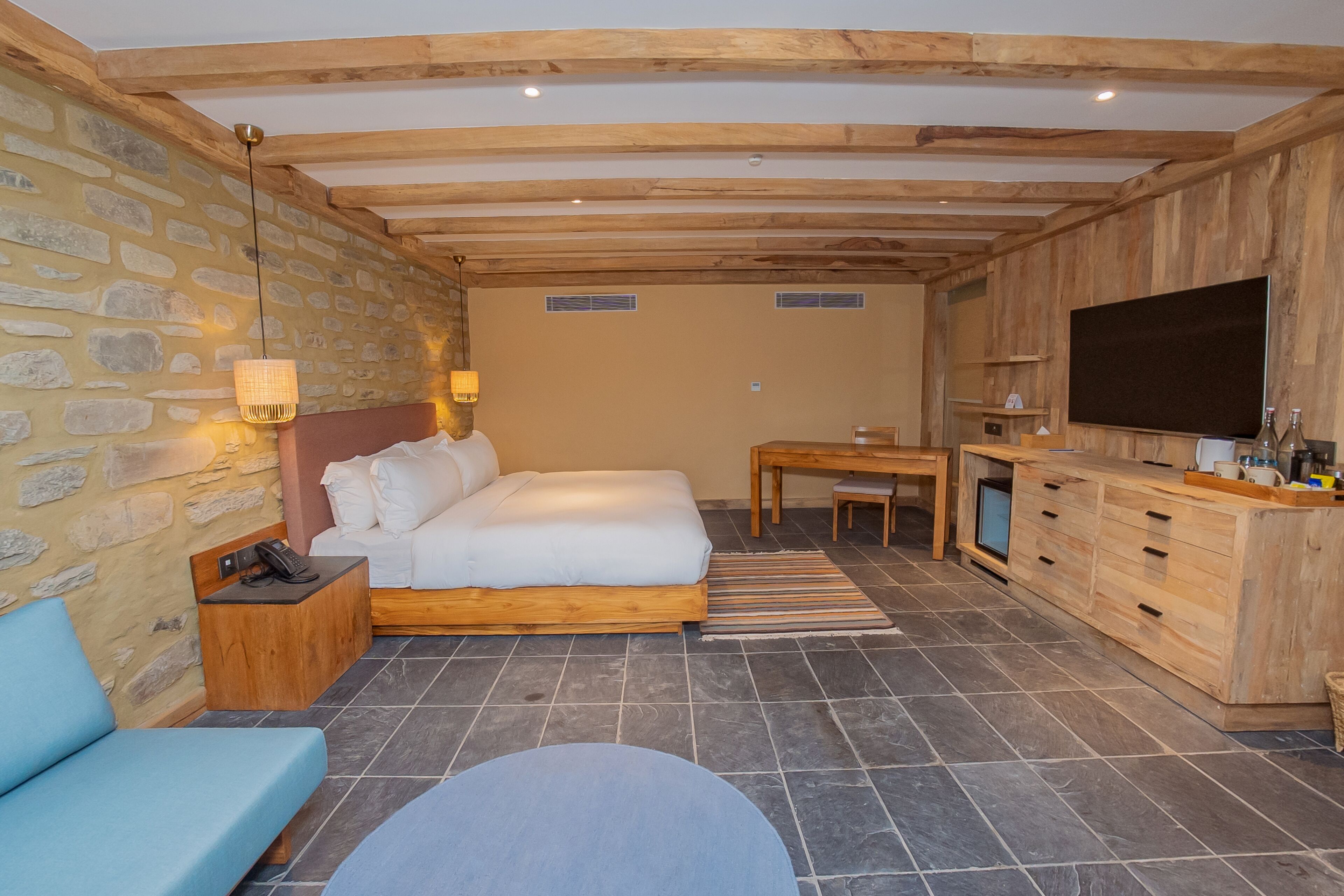 Un dormitorio con cama, mesita de noche, lámpara y televisión.