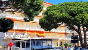 A multi-story building with a restaurant named "La Palmeia" on the ground floor. There is a sign for "INFO PARKING" and a "3m" height restriction sign.