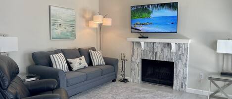 Una Smart TV, una chimenea, libros, un reproductor estéreo