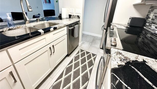 Una cocina moderna con un lavamanos doble, electrodomésticos de acero inoxidable y un tapete estampado.