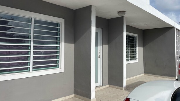 A modern building with a grey facade, white trim, and a tiled entrance. - studio at carolina (Carolina)