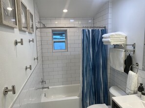 Regadera, secadora de cabello, toallas, papel de baño