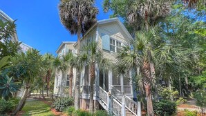 A two-story house with a front porch, surrounded by palm trees and a well-maintained garden. - Yellowfin in the Steinhatchee Landing (Steinhatchee)