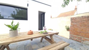 Ein Holztisch mit einer Topfpflanze und einem Terrakottatopf.