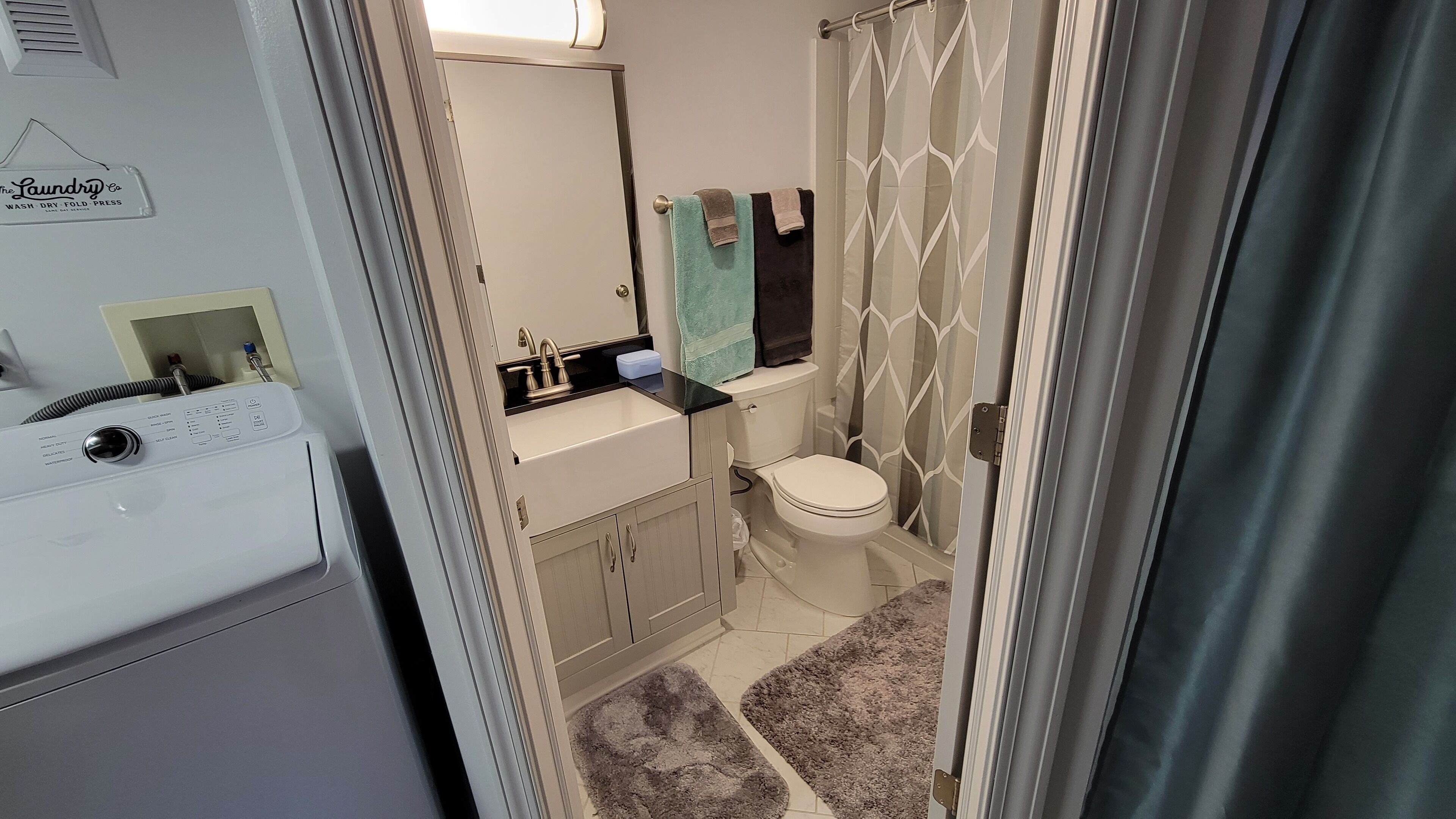 Un baño pequeño con inodoro, lavamanos y un cartel de lavandería a la vista.