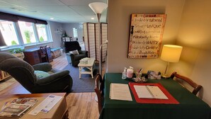 A cozy hotel room with a dining area, a large window, a decorative wall sign, and a lamp. - Private entrance/space. Peaceful getaway. Close to events. King bed. 
Amenities! (Dubuque)