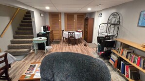 A cozy living room with a staircase, a dining area, and a bookshelf. - Private entrance/space. Peaceful getaway. Close to events. King bed. 
Amenities! (Dubuque)