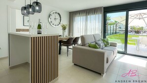 Ein modernes Wohnzimmer mit einer Couch, einem Essbereich und einer Kücheninsel.