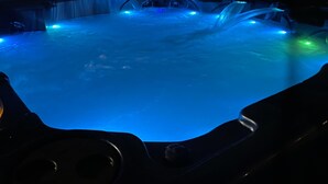 Een hottub met blauwe verlichting en een waterval.