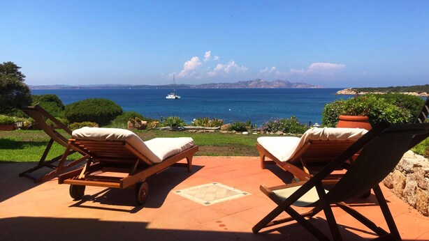 A patio with two lounge chairs facing a scenic ocean view. - Cala del Faro - Maestrale (Arzachena)