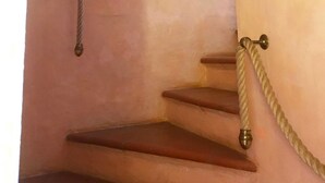 A staircase with a rope handrail and a decorative wall piece. - Cala del Faro - Maestrale (Arzachena)