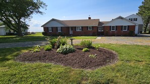 A two-story brick house with a well-maintained lawn and garden. - New Waterfront! Drop Anchor on Brannocks Bay. An Amazing waterfront retreat! (Cambridge)