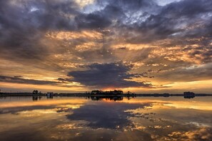 Ein ruhiger See spiegelt einen Sonnenuntergangshimmel mit Wolken.