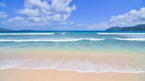 Uma praia com águas azul-claras e uma faixa de areia.