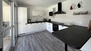 Een moderne keuken met witte kastjes, een zwart aanrecht en een inbouwoven.