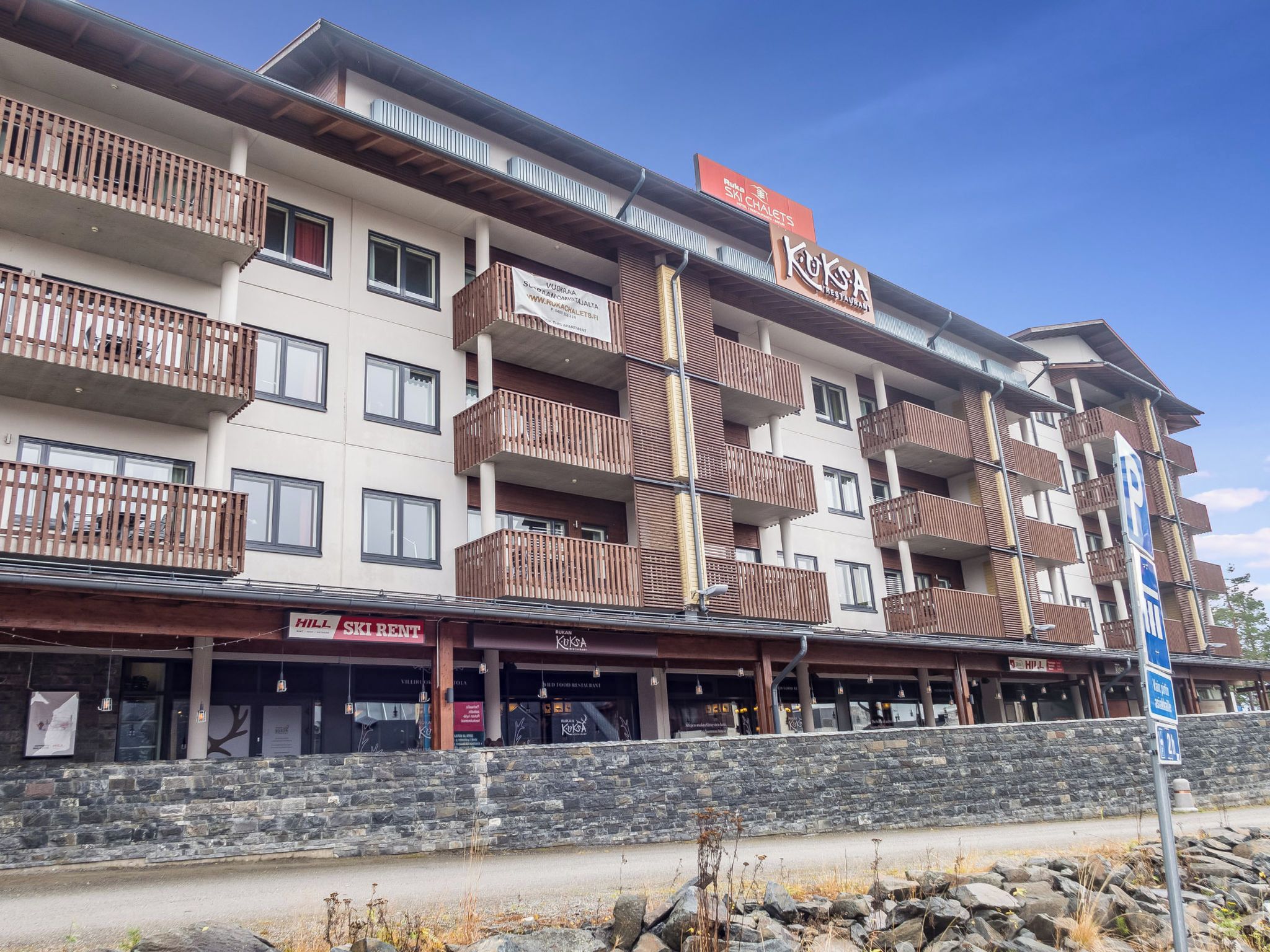 A multi-story hotel with balconies, a ski chalet sign, and a restaurant named 'KUKSA'.