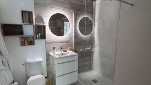 Ein modernes Badezimmer mit Toilette, Waschbecken und Dusche.