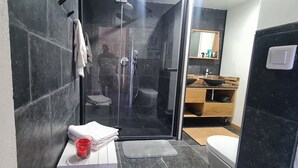 A modern bathroom with a glass-enclosed shower, a wooden vanity with a sink, and a toilet. - 100m de la Plage,maison Face à la Mer! Idéale Pour de Belles Vacances en Famille (Brando)