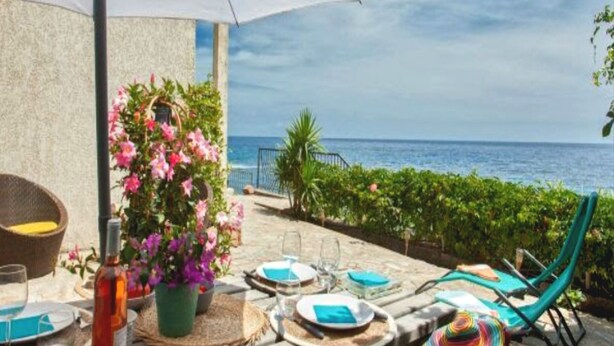 An outdoor dining area with tables set for two, overlooking the sea. - 100m de la Plage,maison Face à la Mer! Idéale Pour de Belles Vacances en Famille (Brando)