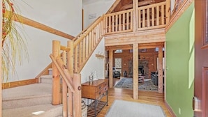 A wooden staircase leading to a lofted area with a view of a living room. - 5BR MOUNTAIN LODGE: 2MIN TO SLOPES, ARCADES FOOSBALL, GOLF WATERPARK, SLEEPS S14 (McGaheysville)