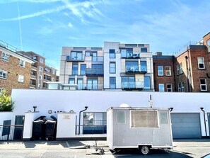 A multi-story building with a white facade, a small white trailer, and a sign indicating 'Pindaria House.' - 3bdr Hoxton Flat Near Old st, shoreditch + balcony (London)